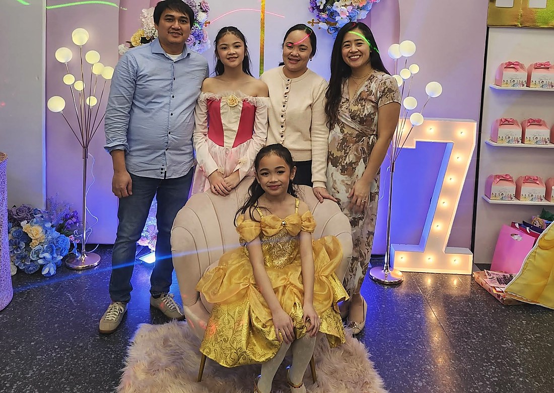A princess themed birthday with the family gathered at the backdrop