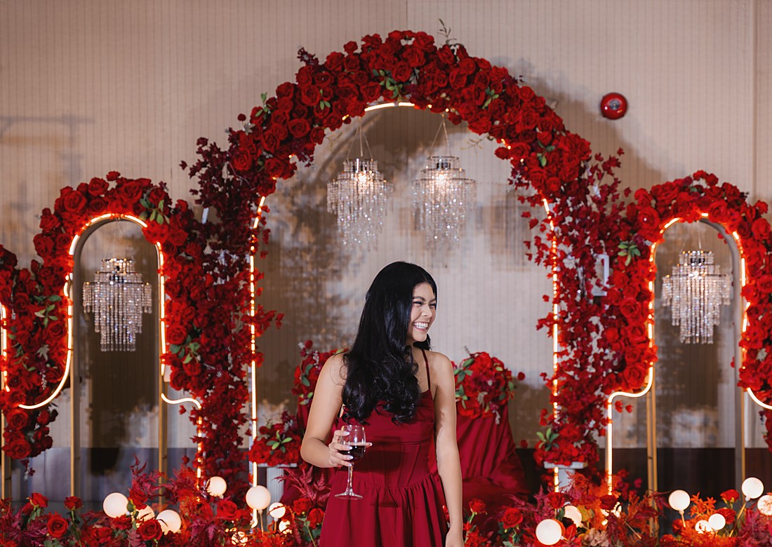 A guest in a red cocktail dress on the mirrored stage