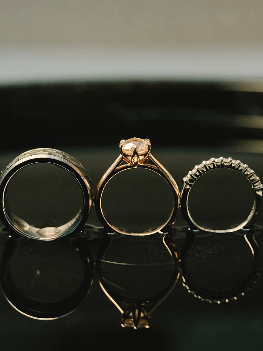 Three wedding rings photographed close on a dark surface