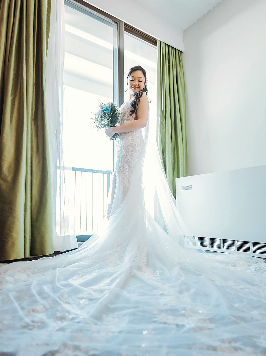 A bride at a window with her train spread across the floor